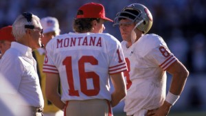 TEMPE, AZ - NOVEMBER 6:  Quarterbacks Steve Young #8 and Joe Montana #16 of the San Francisco 49ers discuss strategy with head coach Bill Walsh during the game against the Phoenix Cardinals at Sun Devil Stadium on Novemer 6, 1988 in Tempe, Arizona.  The Cardinals won 24-23.  (Photo by George Rose/Getty Images)